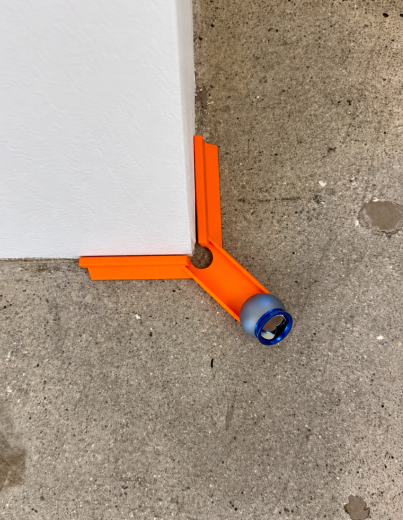 Outside corner control jig fitted over an outside wall corner, holding the Dusty reflector 2 inches off both faces.